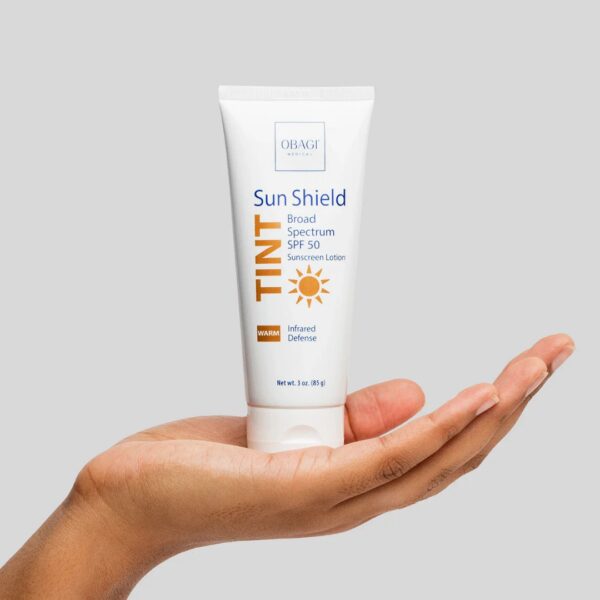 SPF Sun Shield by Obagi in a womans hand that is holding bottle